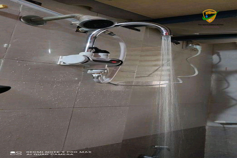 Modern bathroom shower with wall-mounted instant water heater installed by Foli-Tech Plumbing in Ghana.